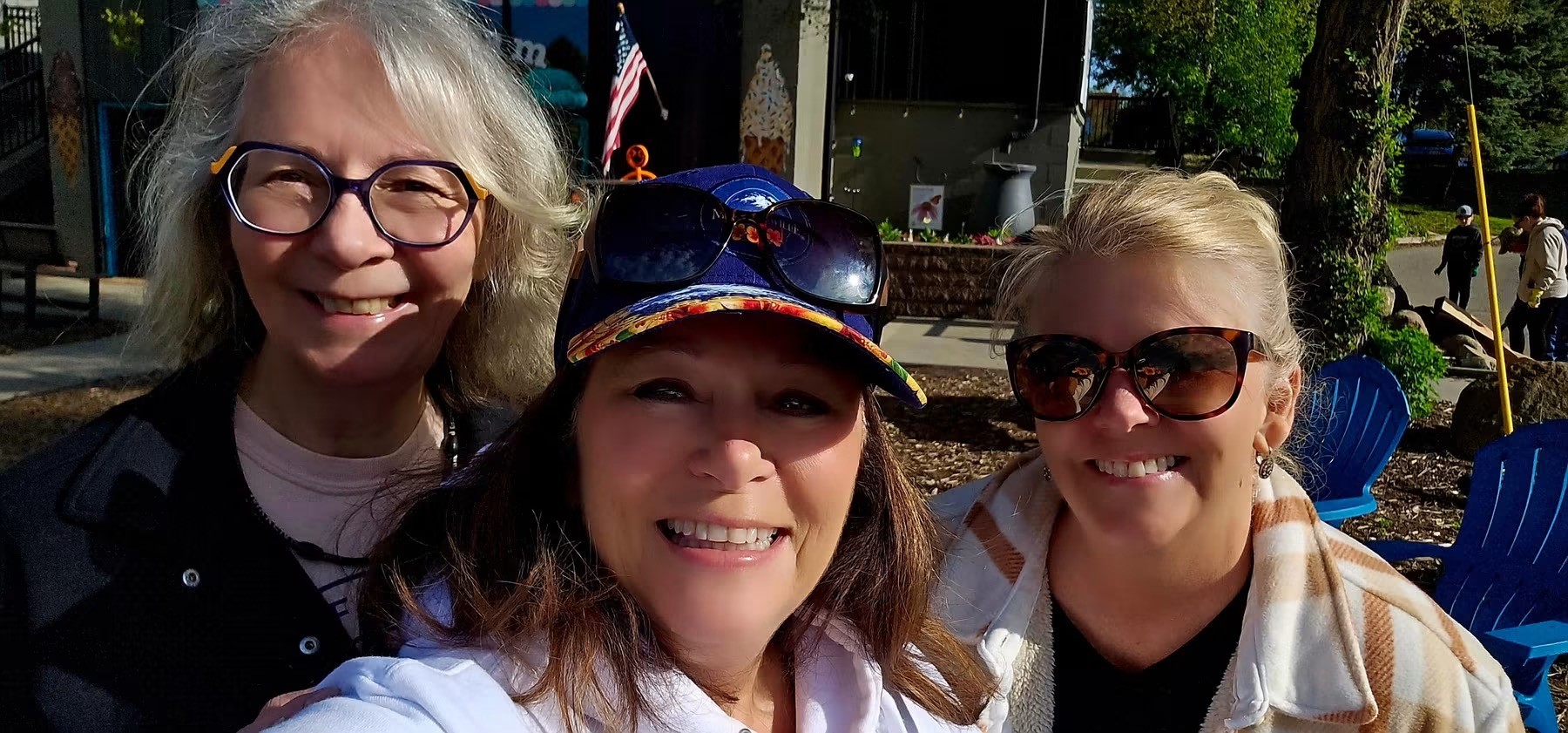 Three GFWC members smiling at an outdoor venue