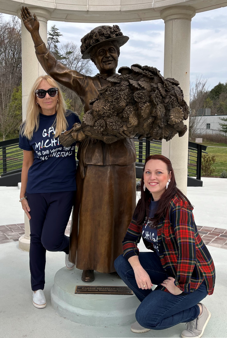 Two GFWC members posing with a statue of Carrie Chapman Catt.